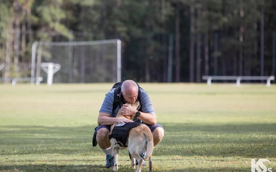 Veteran Mark Heid gives some love to his service dog, Mama Bear, at K9s For Warriors' headquarters in Ponte Vedra Beach, Fla. Heid was paired with Mama Bear in December 2022.